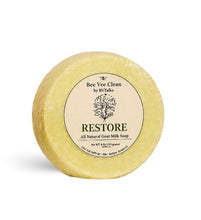 Load image into Gallery viewer, A round, pale yellow bar of soap labeled 'RESTORE' by Bee Vee Clean, photographed on a clean white background.