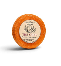 Load image into Gallery viewer, An orange-brown circular soap bar with a cream-colored paper label reading 'The Shift' by Bee Vee Clean, photographed on a white background with a soft shadow.
